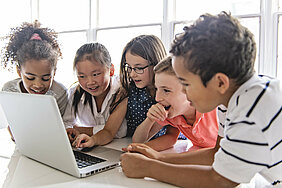 Los estudiantes se sientan juntos frente a un portátil y aprenden